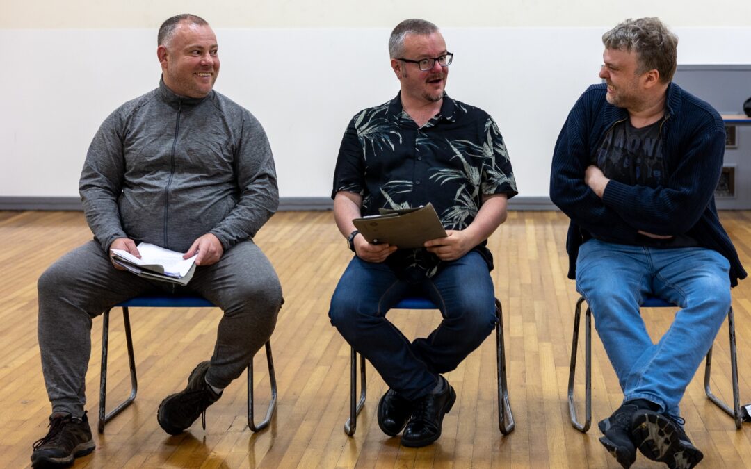 3 men sitting smiling