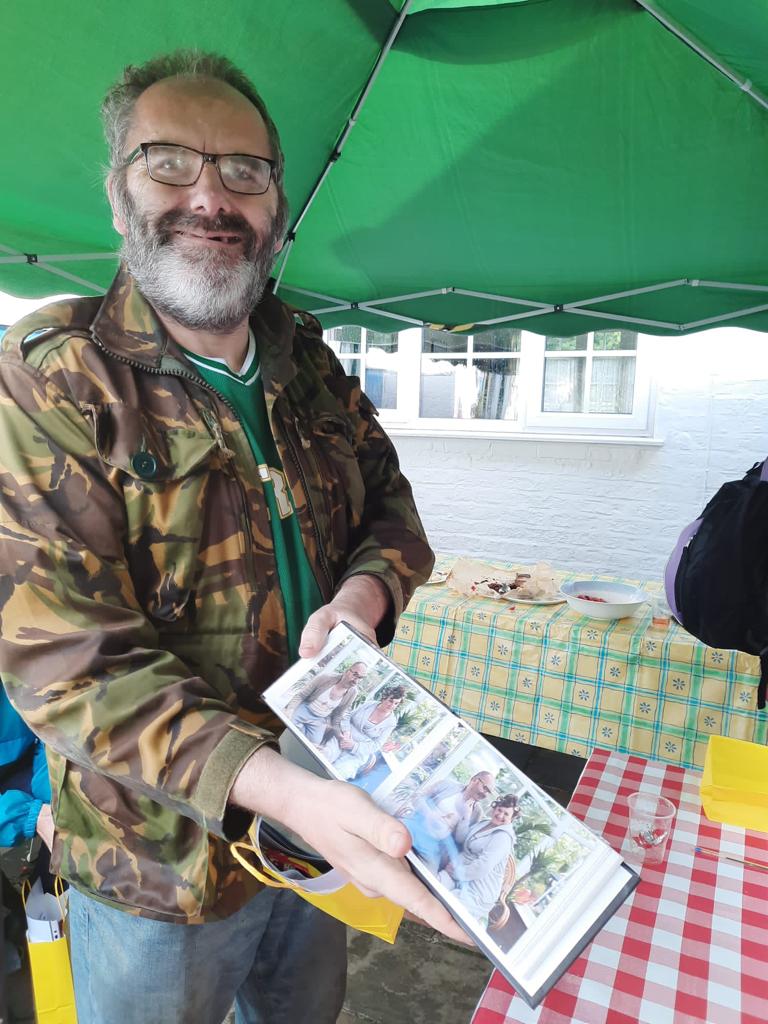 Actor smiling holding photo album of images from Oglebox